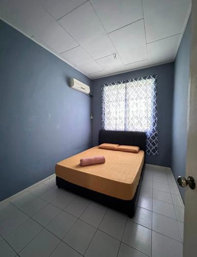 1 dormitorio con 1 cama en una habitación con ventana en Melody D’Rimba Sandakan, en Sandakan