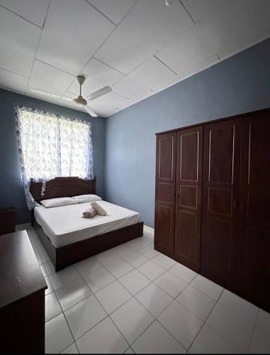 1 dormitorio con cama y pared azul en Melody D’Rimba Sandakan, en Sandakan