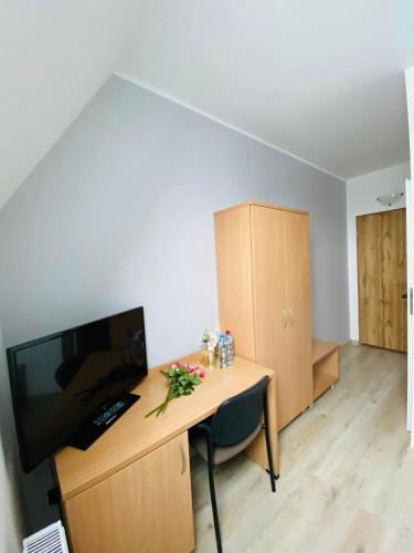 a room with a desk with a tv and a computer at HOTEL MILO - Noclegi Bartoszyce in Bartoszyce