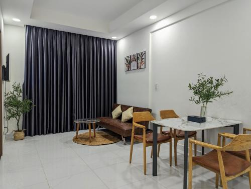 - un salon avec un canapé, une table et des chaises dans l'établissement A cozy full service Osimi Apart- hosted by Minh Hai Resort, à Phú Mỹ