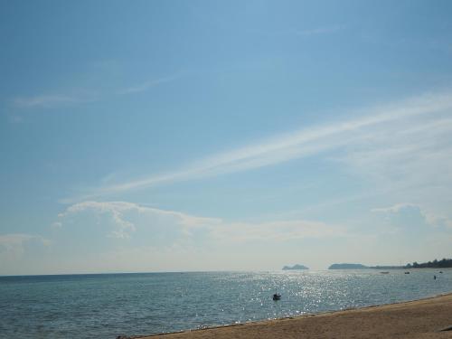 a rainbow in the sky over a beach at The Scenery Beach Resort in Baan Khai