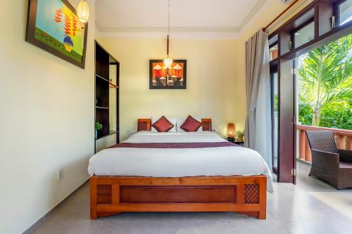 a bedroom with a bed and a large window at Loc Phat Hoi An Homestay in Hoi An