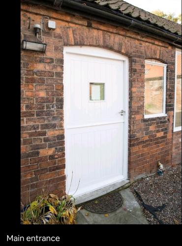 a white garage door on a brick building at 300 year old barn conversion in Retford