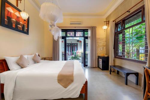 a bedroom with a large white bed and a window at Loc Phat Hoi An Homestay in Hoi An