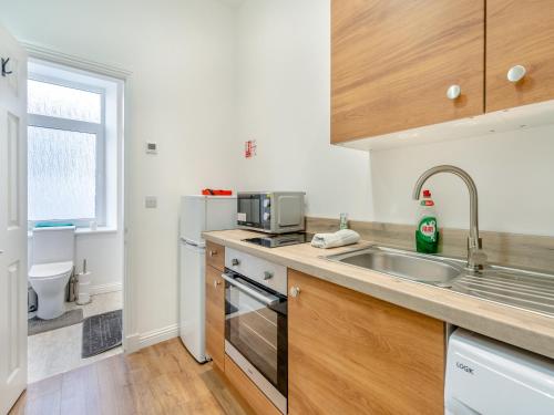 a kitchen with a sink and a microwave at Apartment One - Uk44284 in Arbroath