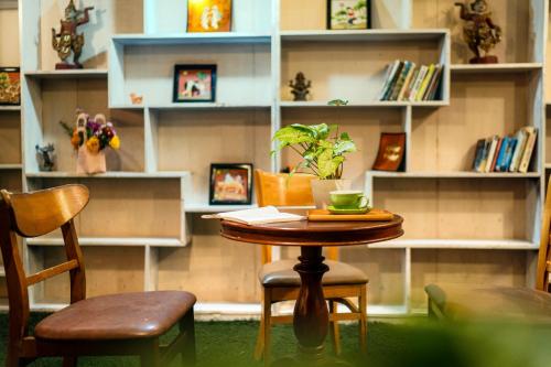 a table and two chairs in a room with shelves at Loc Phat Hoi An Homestay in Hoi An