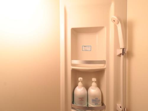 a refrigerator with milk bottles inside of it at Business Ryokan Iroha in Minokamo