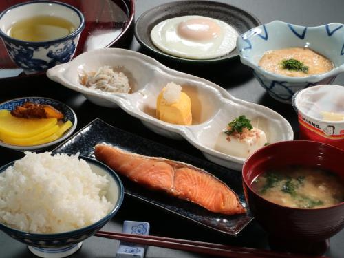 a table topped with bowls of food and rice at Business Ryokan Iroha in Minokamo