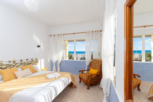 a bedroom with a bed and a chair at Fidalsa Pacific Beach in Guardamar del Segura