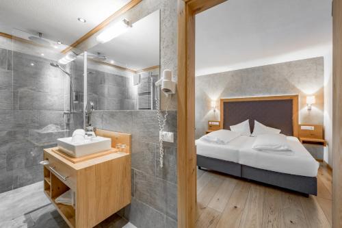 a bathroom with a bed and a shower and a sink at Tilia living in Ried im Oberinntal