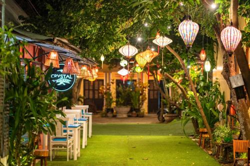a restaurant with tables and chairs and chinese lights at Loc Phat Hoi An Homestay in Hoi An