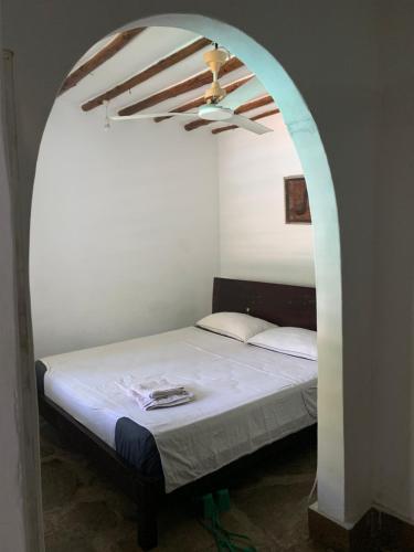 1 dormitorio con 1 cama y ventilador de techo en Villascape Malindi Entire Villa en Malindi
