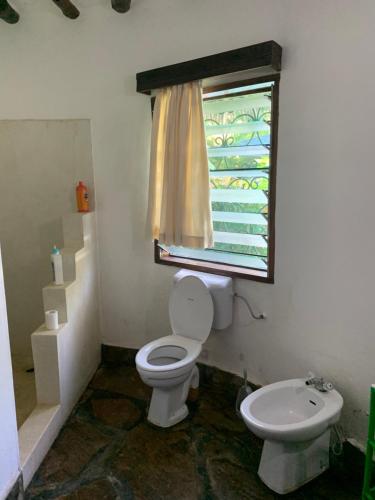 a bathroom with a toilet and a window at Villascape Malindi Entire Villa in Malindi