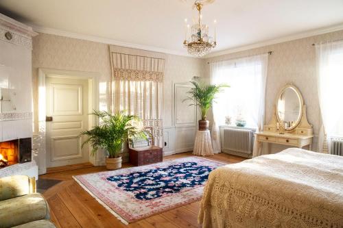 a bedroom with a bed and a fireplace and a mirror at Långbro Gård i Mölnbo in Mölnbo