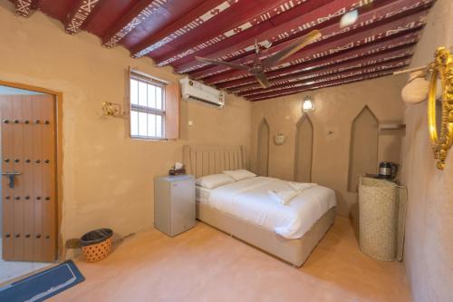1 dormitorio con 1 cama blanca en una habitación en بيت نُزل السلام Bait Salam inn, en Al Ḩamrāʼ