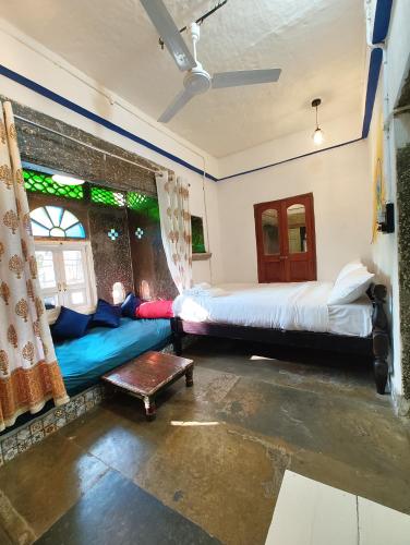 a bedroom with two beds and a window at Barefoot Boutique Hotel Udaipur in Udaipur