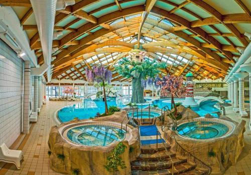 una gran piscina con 2 árboles grandes en un edificio en Cherry House en Čatež ob Savi