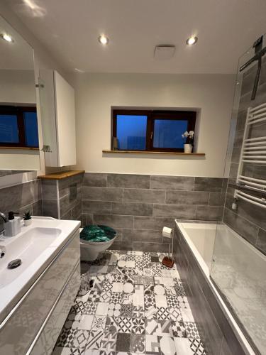 a bathroom with a tub and a sink and a toilet at Blush Jungle in Dublin