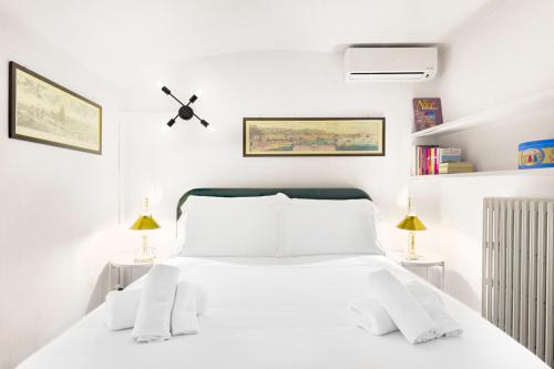 - une chambre blanche avec un lit blanc et deux lampes dans l'établissement Lussuoso Appartamento nel Cuore del Centro Storico, à Bologne
