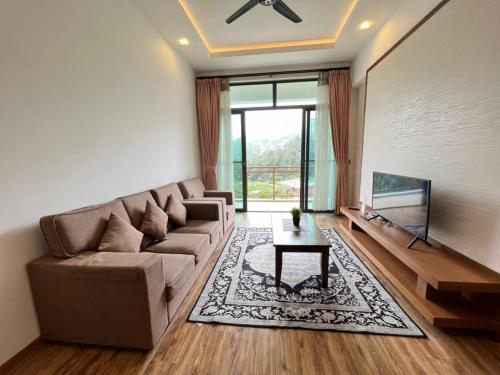 a living room with a couch and a tv at Delisha 2 Homestaymuslim's 3R2B The Retreat Nova Kae Farm in Brinchang