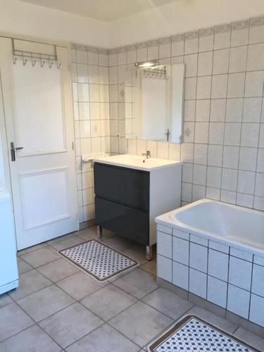 une salle de bain avec une baignoire, un lavabo et un miroir dans l'établissement De brique & de bois, Lac du Der, à Louze