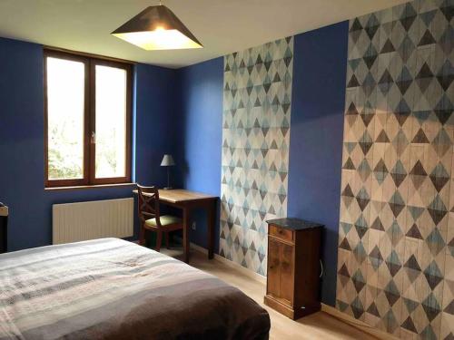 a bedroom with a bed and a desk and a window at De brique & de bois, Lac du Der in Louze