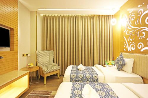a hotel room with two beds and a chair at JRD Luxury-Business Hotel in New Delhi