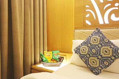a bed with a pillow and a basket of chips at JRD Luxury-Business Hotel in New Delhi