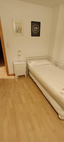 a bedroom with two beds and a night stand at En el pleno centro de Biescas con garaje, ascensor y WiFi in Biescas