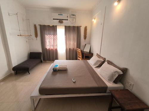 a small room with a bed and a couch at J-House, spacious apartments with balconies, Thalassa 1min away in Siolim
