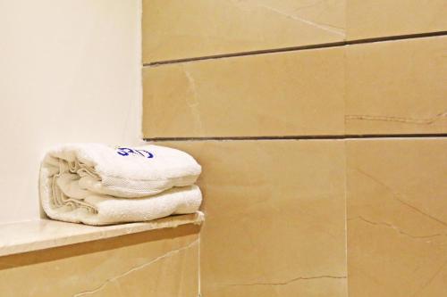 a stack of towels sitting on a shelf next to a stack of boxes at JRD Luxury-Business Hotel in New Delhi