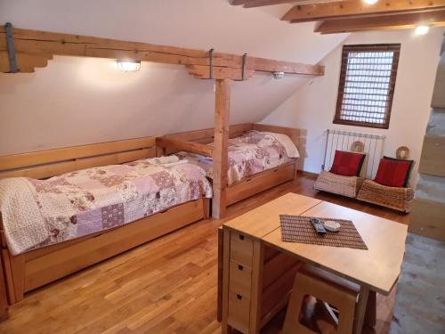 ein Schlafzimmer mit 2 Betten und einem Tisch darin in der Unterkunft Divčilend-Mesko vajat in Divčibare