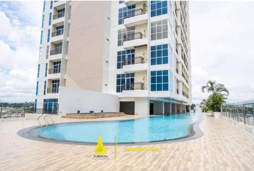 a building with a swimming pool in front of a building at Formosa Residence Apartment Nagoya Batam 15th Free Netflix in Jodoh
