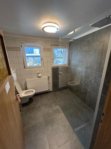 a bathroom with a shower and a toilet and a sink at Austrian Motel Heiss in Prutz