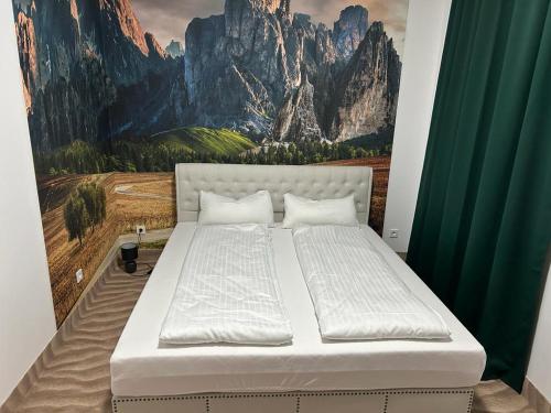 Bett in einem Zimmer mit Wandgemälde in der Unterkunft Weißes Haus in Plauen