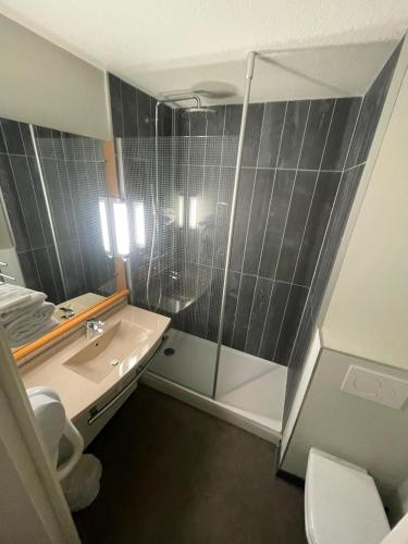une salle de bain avec une douche, un lavabo et des toilettes dans l'établissement ibis Saint-Die, à Saint-Dié-des-Vosges