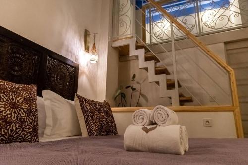 a bedroom with a bed with towels and a staircase at Riad contessa in Marrakech