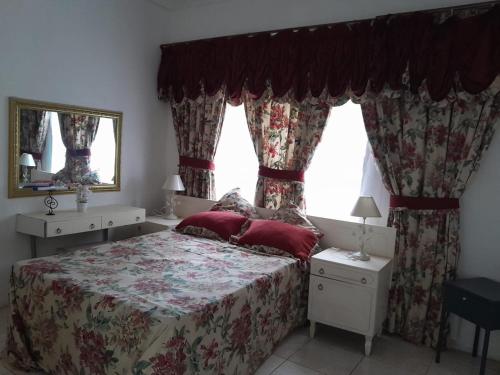 a bedroom with a bed with red pillows and a window at Scenic Guesthouse in Hibberdene