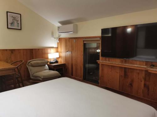 a hotel room with a bed and a flat screen tv at 枕窗听雨客栈 in Suzhou