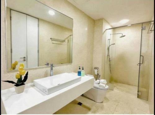 Un baño con lavabo, ducha e inodoro. en jazz suite 2 bedroom sea view apartment, en Tanjung Bungah