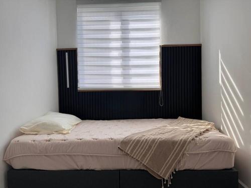 a bed in a bedroom with a window at Seindah Seribong Homestay KB in Kota Bharu