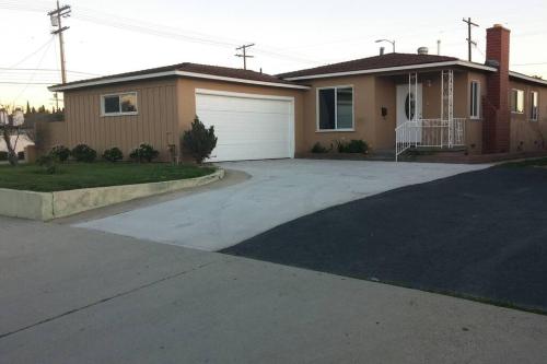 a driveway in front of a house with a garage at Family getaway 3 BR 2 Bath home in Lomita, CA. in Los Angeles