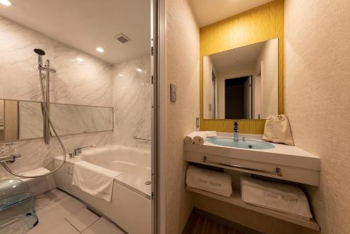 een badkamer met een bad, een wastafel en een douche bij Hotel Cocoa - Vacation STAY 05828v in Sakura