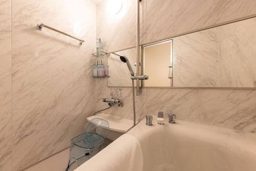 a bathroom with a tub and a mirror and a toilet at Hotel Cocoa - Vacation STAY 24777v in Sakura