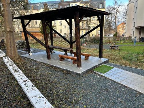 a picnic shelter with two benches in a park at Weißes Haus in Plauen