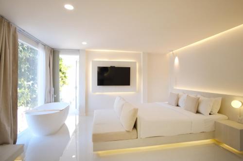a white room with a white bed and a window at Sawasdee Coco in Ko Samed