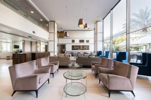 a lobby with chairs and tables and windows at Holiday Inn Express - Antofagasta by IHG in Antofagasta