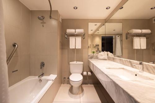 a bathroom with a toilet and a tub and a sink at Holiday Inn Express - Antofagasta by IHG in Antofagasta