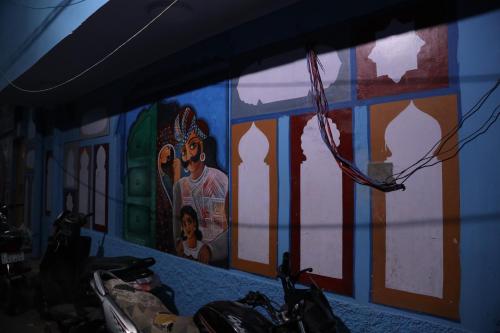 una pared con un mural en ella con motocicletas estacionadas delante en MOON NIGHT GUEST HOUSE, en Jodhpur
