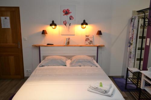 Una cama en una habitación con dos toallas. en la maison des coquelicots, en Saint-Genès-de-Fronsac